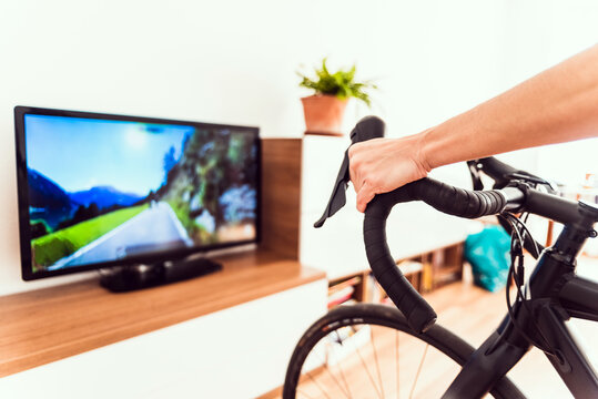 Woman exercises indoors using her bike for a virtual race.