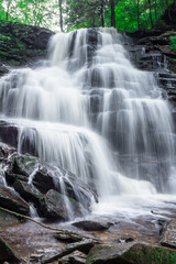 Fototapeta na wymiar A large waterfall over some water