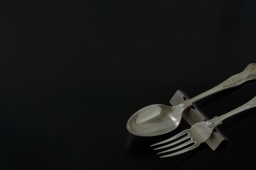 Lay out of vintage old silver cutlery. made in England. 
spoon, fork on black background.  

Top view photo ・dim lighting soft focus image. 
