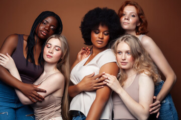 young pretty caucasian, afro, scandinavian woman posing cheerful together on brown background, lifestyle diverse nationality people concept