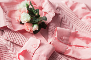 Background with fashionable clothes. Pink jersey and shirt with a bouquet of flowers. Beauty blog concept.