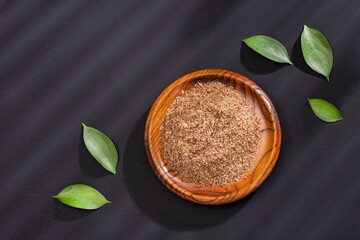 Linum usitatissimum - Crushed flax seeds in the wooden bowl