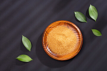 Saccharum officinarum - Organic brown sugar in the wooden bowl