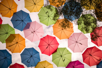 Colorful floating umbrellas hang above the street. Umbrella Sky Project in Coral Gables, Miami,...