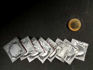 Condom a male contraception method packets on black background with space for text