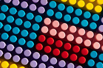 children's play background: the plane of plastic multi-colored bricks, blur, selective focus