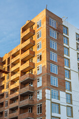 Fototapeta premium construction of iron-concrete high-rise building. Construction workplace in the summer. Details of unfinished building on the construction site. The erection of a new residential multi-storey house