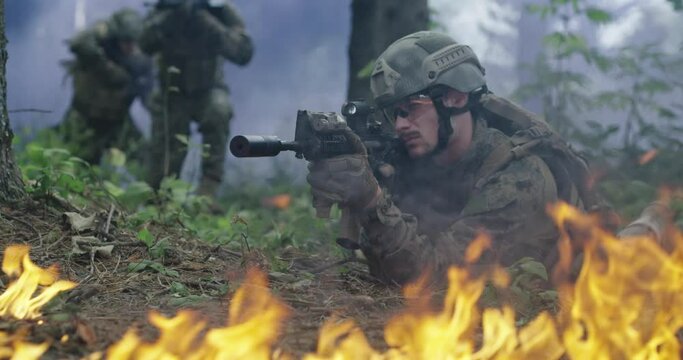 Special Forces soldiers in action. Elite squad moves through fire and smoke in forest