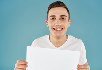 Handsome guy with white sheet of paper advertising mockup Copy Space