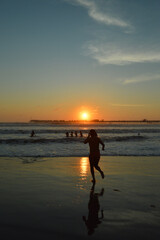 people on the beach play wit the sunset