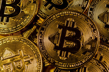 Close-up of gold Bitcoin coins on yellow background.