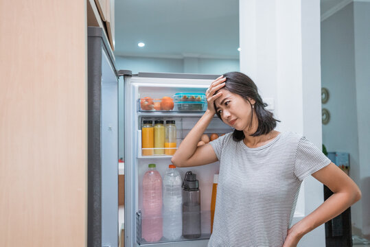 Dissapointed Woman While Opening The Fridge Door Before Cooking