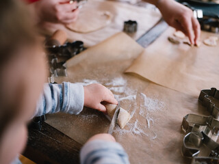 Mädchen schneidet Teigrolle zuhause beim Plätzchen backen