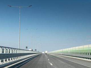 A7 highway in Romania connecting Moldova area with Bucharest. The part of the road next to Bacau city during a sunny day with blue sky. Indicator showing city names.