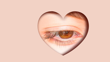 Beautiful girl gray eye in a hole in the shape of a heart. Shining skin color foreground - obrazy, fototapety, plakaty