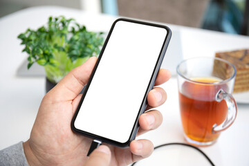 male hands holding phone with isolated screen connected to powerbank
