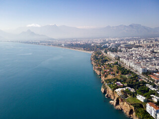 Fototapeta na wymiar Aerial photograph of Antalya bay in Antalya city from high point of drone fly on sunny day in Turkey. Amazing aerial cityscape view from birds fly altitude on beautiful town and sea full of yahts