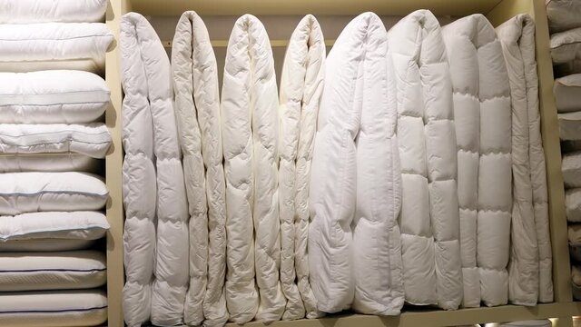 blankets and pillows with different filling, size and fabric material on the store shelves