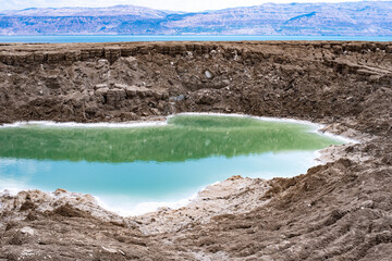 Emerald, blue colour of water lake in brown mountains. Silence and beauty of nature attracts people. Wonderful and amazing places there are  in many parts of our planet. Outdoors