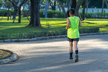 Fototapeta na wymiar Asian runner jogging in the park in summer morning
