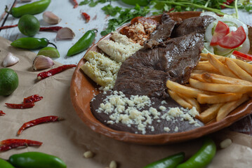arrachera mexicana con enchiladas y papas fritas, platillo mexicano con chiles alrededor