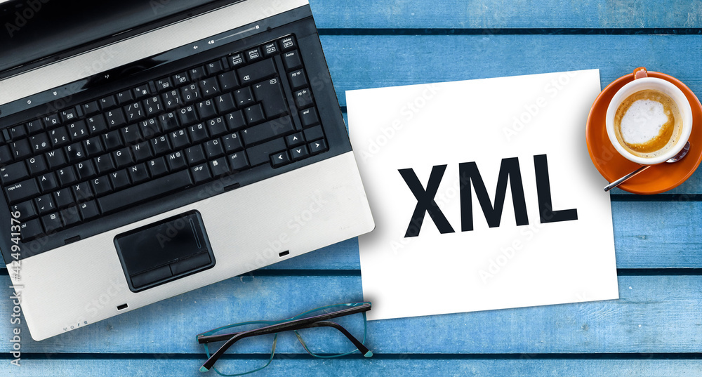 Poster extensible markup language. word xml on paper and laptop on desk
