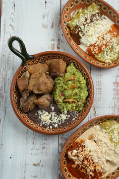 platillo mexicano t&iacute;pico de la zona centro y huasteca del pa&iacute;s, carnitas con guacamole y frijoles negros con salsa de crema, verde, roja y picante.