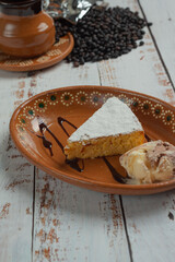 postre de pan mexicano con azucar glass y una bola de helado con café acompañando