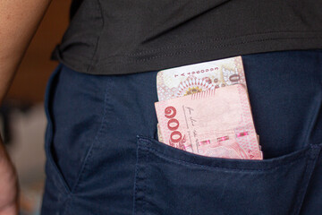 One hundred baht in a man's pocket