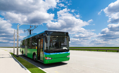 Electric bus at a stop is charged by pantograph	
