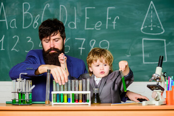 our challenge is our progress. Back to school. Laboratory test tubes and flasks with colored liquids. father and son at school. teacher man with little boy. researcher carrying out research in lab