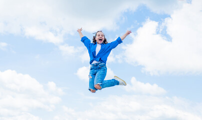 cheerful child jump in casual denim apparel outdoor, happiness