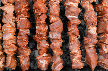 Cooking kebabs on coals outside. Frying marinated meat, top view. Concept picnic, camping, opening of the kebab season