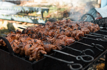 Outside charcoal grilling of meat. Barbecue cooking, fragrant smoke, selective focus. Concept picnic, camping, opening of the kebab season