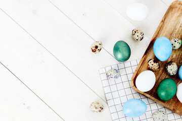 painted eggs on wooden board and plaid fabric Easter holidays traditions