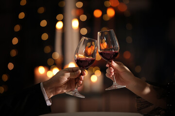 Couple clinking glasses at Valentine's day dinner in restaurant, closeup