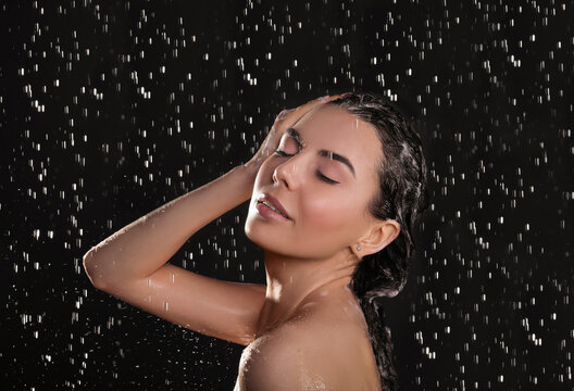 Young Woman Washing Hair While Taking Shower On Black Background