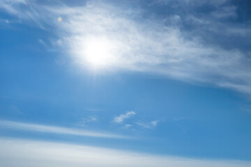 Fototapeta premium Bright sun and fluffy white clouds in blue sky
