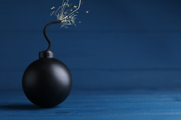 Old fashioned fuse bomb on blue wooden table. Space for text