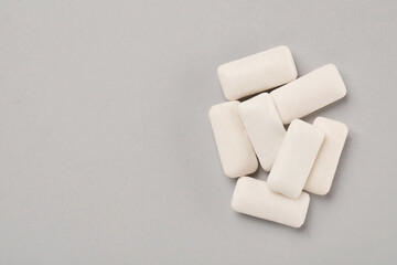 Many chewing gum pieces on light grey background, flat lay. Space for text