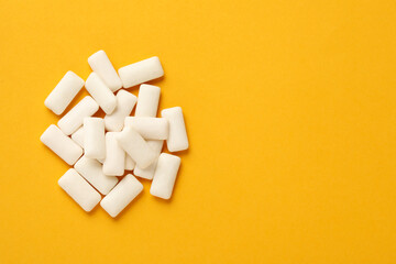 Many chewing gum pieces on orange background, flat lay. Space for text