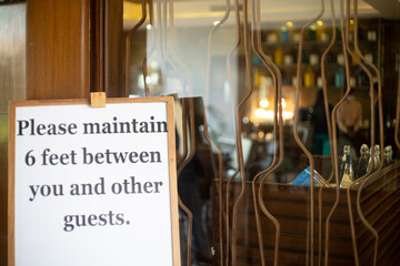 social distancing sign please maintain 6 feet between you and other guests at a restaurant pub, resort hotel spa as businesses open up gradually during the COVID19 coronavirus pandemic