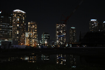 Fototapeta na wymiar ビルのある夜景とそれを映す水溜り