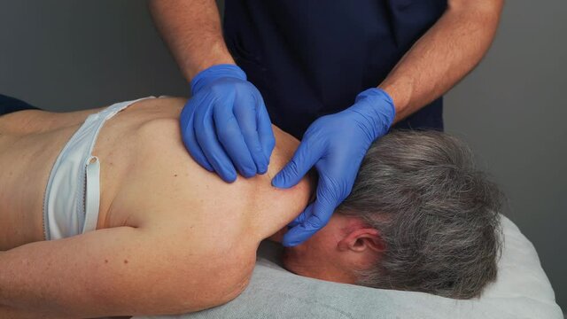 Physiotherapy session, using the Dry Needling technique, for a contracture in the trapezius muscle, in a woman.