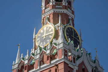 A beautiful tower of the Moscow Kremlin with a clock. Ancient architecture of Moscow. Sunny day. Blue sky.