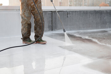 A person using high-pressure equipment to clean the bottom of a water pool. Cleaning dirt. Before...