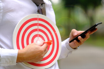 Businessman hand working on table and dart board with target and business growth concept