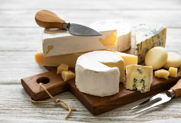 Various types of cheese  on a white wooden  background