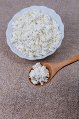 Bowl of farm cottage cheese with wooden spoon
