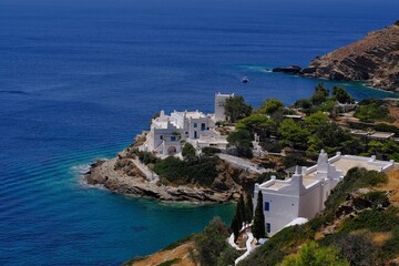 Fototapeta na wymiar Beautiful whitewashed residential building in the Cycladic style architecture next to the sea in Ios Greece